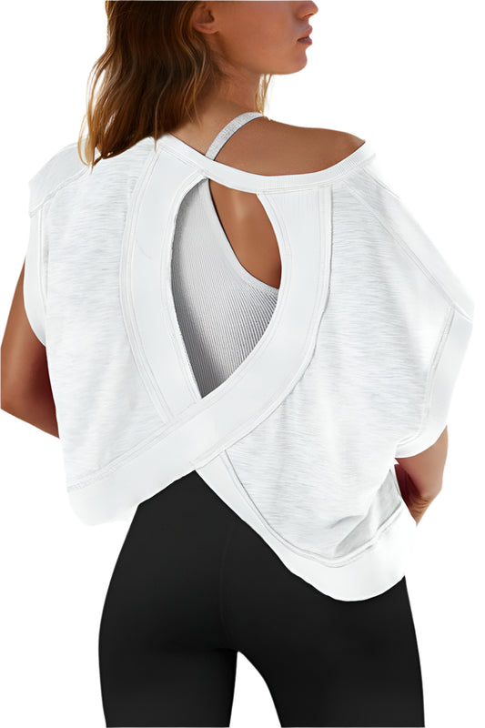 Woman wearing a white layered top with a back cutout design on a plain background