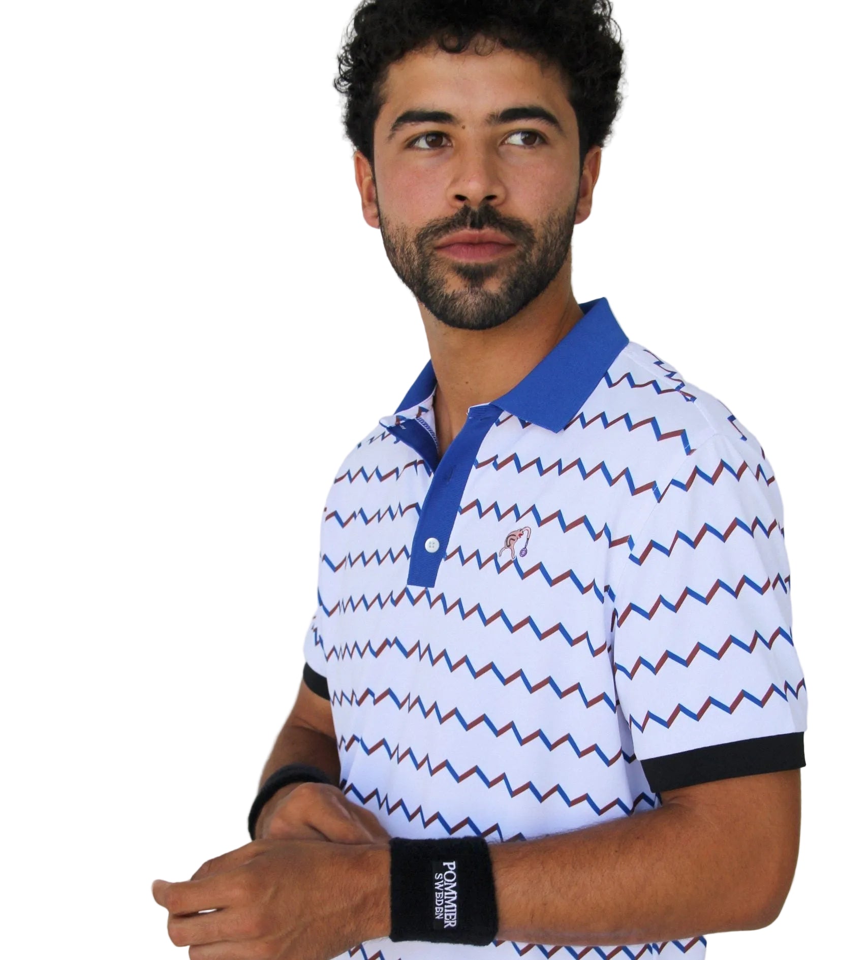 A man wearing a white short-sleeve polo shirt with a blue and red zigzag pattern, a blue collar, and black trim on the sleeve cuffs, paired with a black wristband.