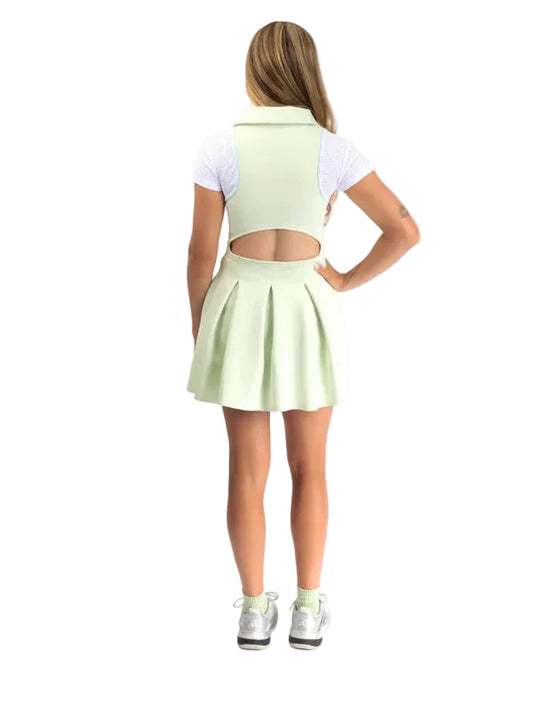 Person wearing a light green dress with cut-out design on a white background
